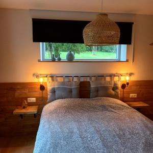 Schlafzimmer mit einem großen Bett und einem Fenster in der Unterkunft Le verger d' Adèle in Vielsalm