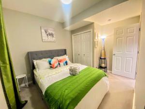 a bedroom with a bed with a green blanket at Cozy Newly Built and Cheerful 1-Bedroom Suite in Calgary
