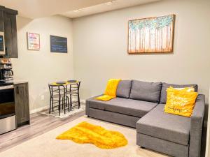a living room with a couch and a kitchen at Cozy Newly Built and Cheerful 1-Bedroom Suite in Calgary