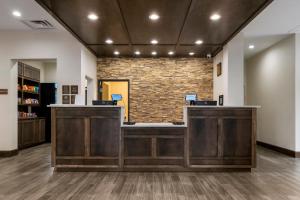 an office with two reception desks and a brick wall at Comfort Suites in Paducah