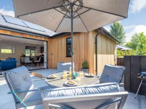 a patio with a table and chairs and an umbrella at Holly Lodge - Uk39639 in Knucklas