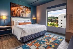 a bedroom with a large bed and a large window at Hotel Indigo Pittsburgh University - Oakland by IHG in Pittsburgh +34 photos