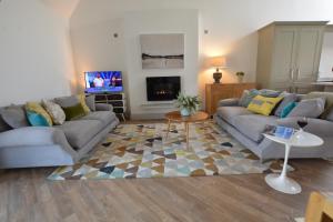 sala de estar con 2 sofás y TV en Badminton, Thorpeness, en Thorpeness