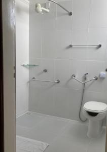 a bathroom with a glass shower with a toilet at Hotel Acalanto in Feira de Santana