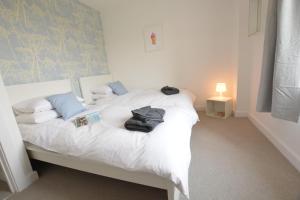 Un dormitorio con una cama blanca con toallas. en Sweet Pea, Southwold, en Southwold