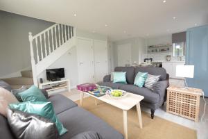 a living room with a couch and a table at Sweet Pea, Southwold in Southwold