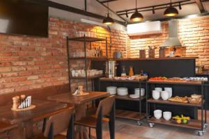 a restaurant with two tables and a brick wall at Hotel Ticiani 13 in Kutaisi