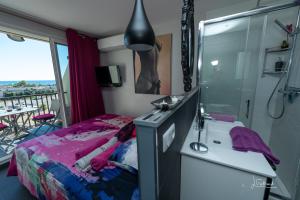 um quarto com uma cama, um chuveiro e um lavatório. em Studio Glamour Naturiste em Cap d'Agde