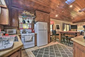 uma cozinha com um frigorífico branco e armários de madeira em Cozy Lakefront Lapeer House with 2 Paddle Boats! em Lapeer
