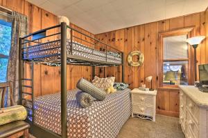 een slaapkamer met een stapelbed in een houten muur bij Cozy Lakefront Lapeer House with 2 Paddle Boats! in Lapeer