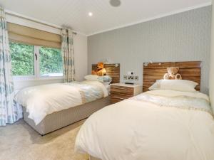 1 dormitorio con 2 camas con osos de peluche en las cabeceras en Lakeside Lodge en Windermere