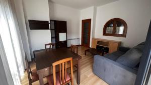 a living room with a table and a blue couch at Apartamentos Redondela - Centro histórico in Redondela