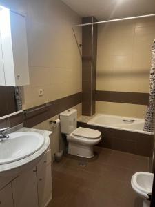 a bathroom with a sink and a toilet and a tub at Apartamentos Redondela - Centro histórico in Redondela