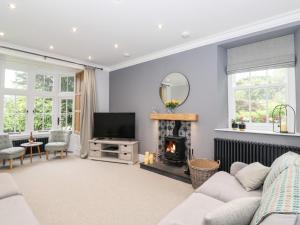 a living room with a fireplace and a television at Eller Close House in Ambleside