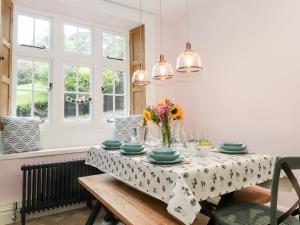 ein Esszimmer mit einem Tisch mit Platten und Blumen darauf in der Unterkunft Eller Close House in Ambleside