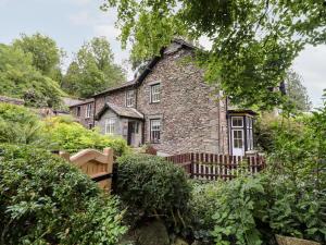 una vieja casa de piedra en medio de un jardín en Eller Close House, en Ambleside