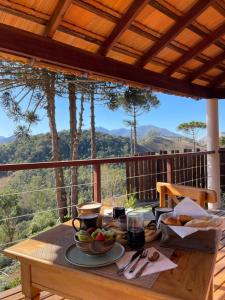 einen Holztisch mit Essen auf dem Balkon in der Unterkunft Atiaia Jungle River Retreat in Visconde De Maua