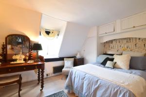 sypialnia z łóżkiem, biurkiem i lustrem w obiekcie Cherry Tree Cottage, Woodbridge w mieście Woodbridge