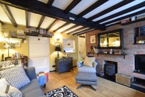 a living room with a couch and a fireplace at Cherry Tree Cottage, Woodbridge in Woodbridge