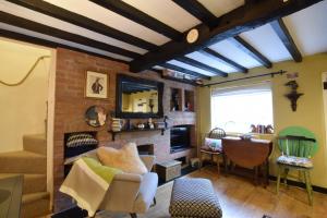 a living room filled with furniture and a brick wall at Cherry Tree Cottage, Woodbridge in Woodbridge