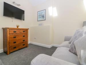 a living room with a couch and a dresser at Bridges Cottage in Torquay