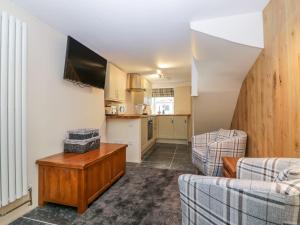 a living room with two couches and a kitchen at Bridges Cottage in Torquay