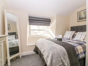 a bedroom with a bed and a mirror at Bridges Cottage in Torquay