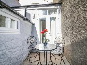 a table and chairs on a patio with a window at Bridges Cottage in Torquay
