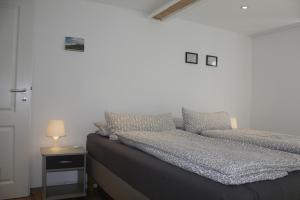 エアランゲンにあるThe Blue Houseのベッドルーム1室(ベッド2台、ランプ付きテーブル付)