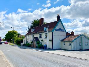 a white building on the side of a street at Cherry Tree Cottage, Woodbridge in Woodbridge