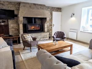 sala de estar con sofá y chimenea en La Ferme de Penanguer, en Loctudy