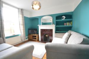 a living room with a couch and a fireplace at Somewhere Only We Know, Aldeburgh in Aldeburgh