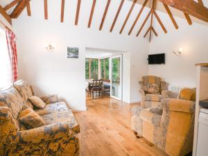 ein Wohnzimmer mit einem Sofa und 2 Stühlen in der Unterkunft Byre Cottage 4 in Pulborough