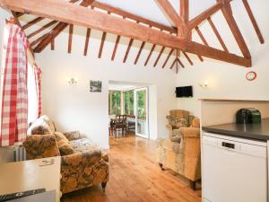 a kitchen and living room with wooden beams at Byre Cottage 4 in Pulborough