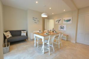 a living room with a table and chairs and a couch at Somewhere Only We Know, Aldeburgh in Aldeburgh +10 photos