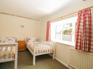 a room with two cribs and a window in it at Byre Cottage 2 in Pulborough