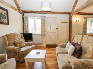 a living room with two couches and a table at Byre Cottage 5 in Pulborough