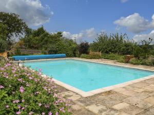 a swimming pool in a garden with flowers at Byre Cottage 2 in Pulborough