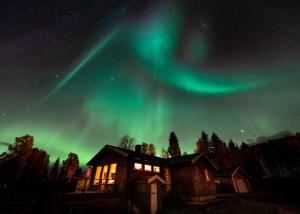 una imagen de la aurora boreal sobre una casa en House in the heart of the Lyngen Alps with Best view, en Lyngseidet