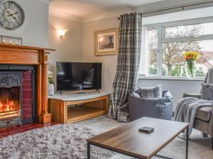 a living room with a fireplace and a tv at Brookside House in Pickering