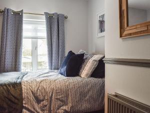 a bedroom with a bed with pillows and a window at Brookside House in Pickering