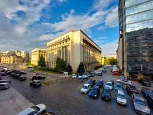 a parking lot with cars parked in front of a building at Rosuites Apartment Accommodation in Bucharest