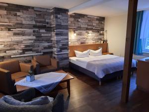a hotel room with a bed and two chairs at Pension Kastanienhof in Zeulenroda