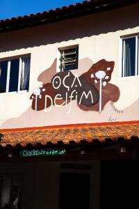 una señal para un restaurante al lado de un edificio en Oca Delfim en Delfim Moreira