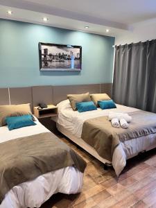 twee bedden in een kamer met blauwe muren bij Ayres Apart Hotel in Federal