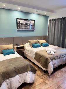 two beds in a room with blue walls at Ayres Apart Hotel in Federal