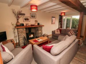 sala de estar con 2 sofás y chimenea en Crumble's Cottage, en York