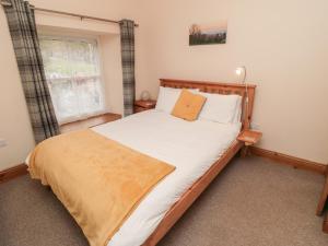 Cama grande en habitación con ventana en Crumble's Cottage, en York