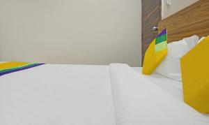 a bedroom with two white beds and a colorful pillow at Itsy By Treebo - AY Plus Hotels in Kharadi