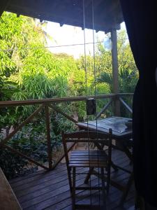 une terrasse couverte avec une balançoire, une table et une chaise dans l'établissement La Perla, à Pipa